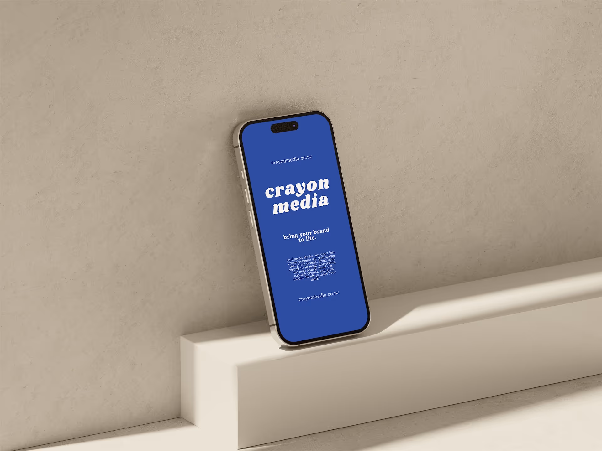 A laptop displaying a website design project on a blue couch, with a dark background. The screen shows text that reads 'WEBSITE DESIGN' and other design elements.