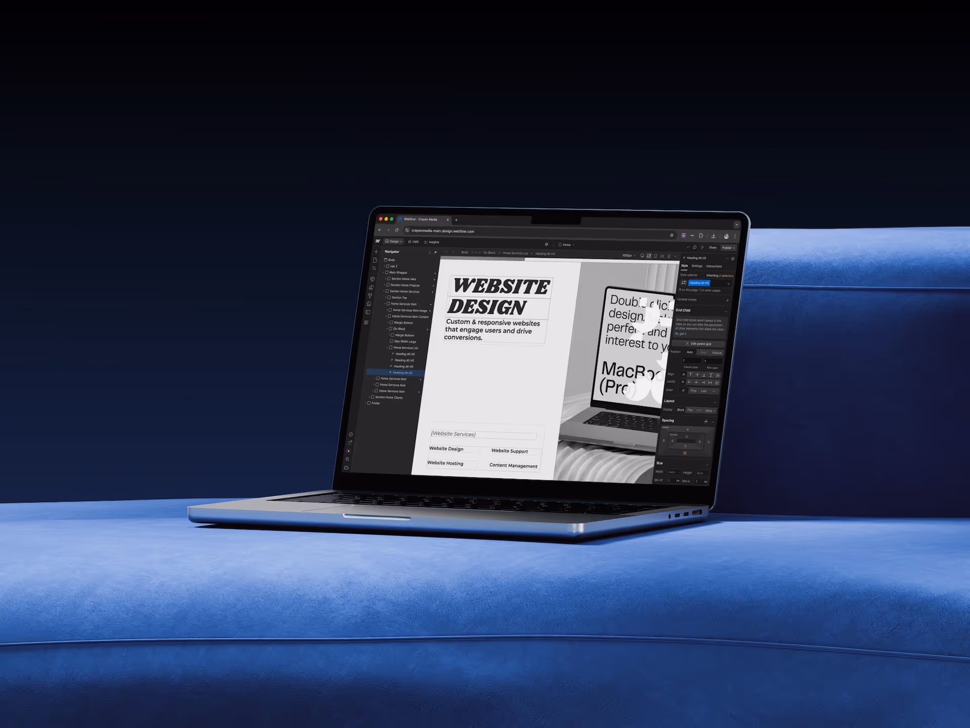 A laptop displaying a website design project on a blue couch, with a dark background. The screen shows text that reads 'WEBSITE DESIGN' and other design elements.